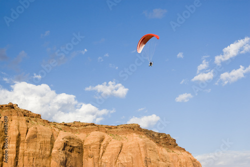 a powered paraglider pilot in flight over Monument Valley