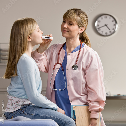 Nurse taking sick patients temperature with thermometer