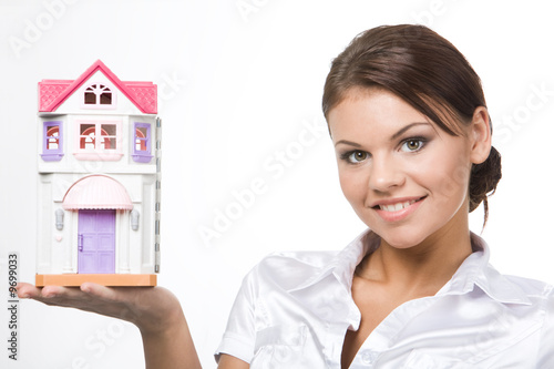 Image of pretty woman holding toy house on her palm