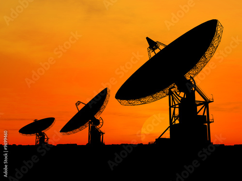 Fototapeta Naklejka Na Ścianę i Meble -  Three satelite dishes over sunset