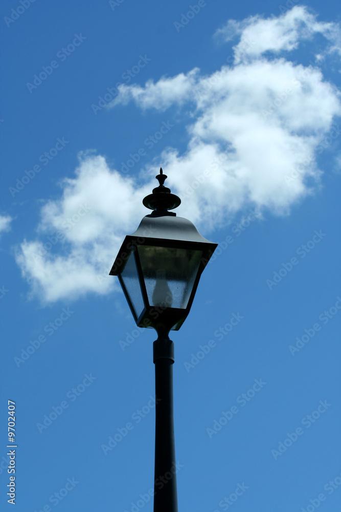 A Black lamp post against blue sky