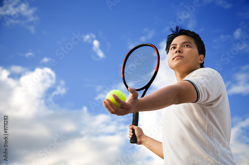 A young sporty asian male playing tennis outdoor © arekmalang