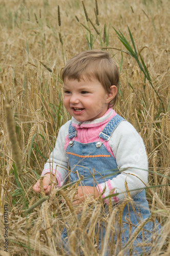 little girl runs across the field of a rye