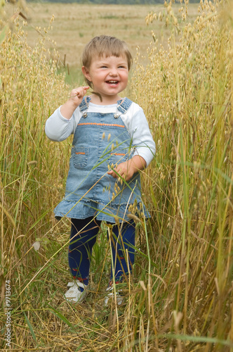 little girl runs across the field of a rye