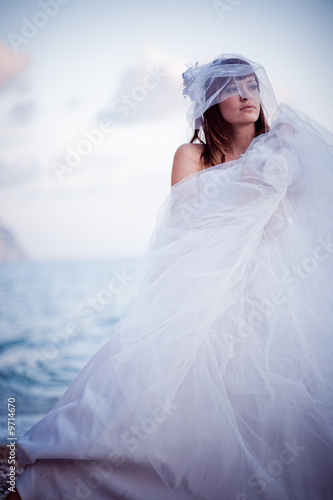 Posing fashion bride in wedding dress outdoors