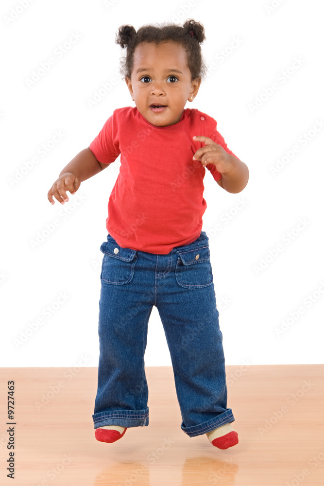 Adorable and beautiful african baby jumping a over wooden floor Adorable and beautiful african baby jumping a over wooden floor