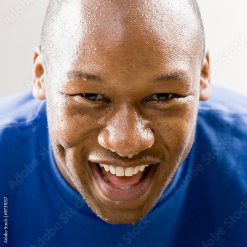 Fatigued man smiling and dripping sweat