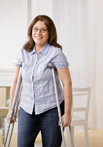 Slika na platnu Injured disabled woman using crutches to walk