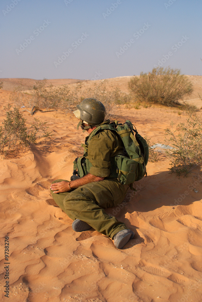 Rear view of man sitting on sand in desert Rear view of man sitting on sand in desert