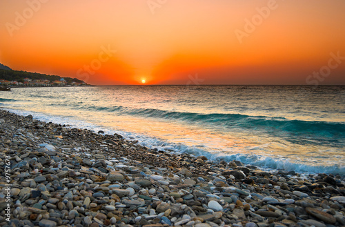 Sunset at Mediterranean beach. Village at Samos Island, Greece.