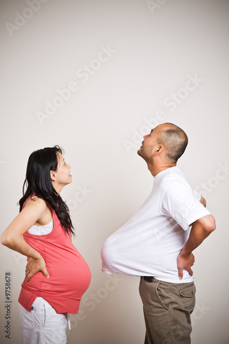 A happy expecting pregnant asian couple looking up