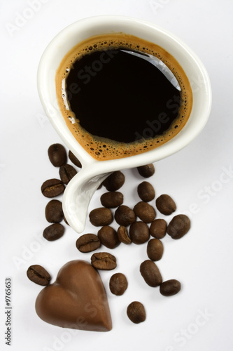 Cup of espresso coffee with heart shaped chocolate candy