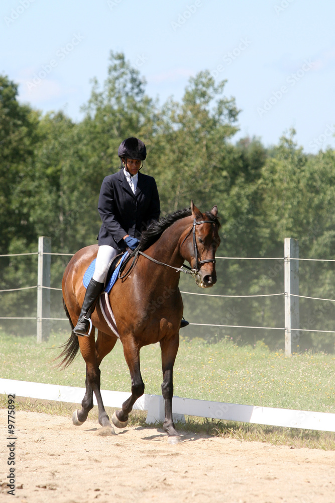 black teenage girl riding a horse with dust from the ground