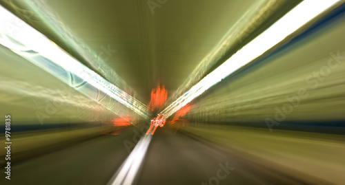 travelling down tunnel with road and lights blurred motion