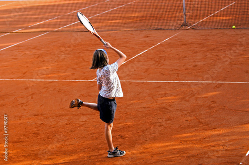 action shot of girl hitting tennis ball