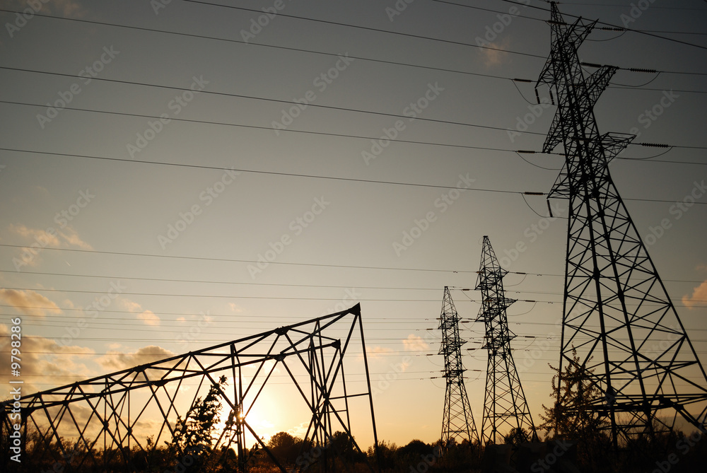 Three standing electrical towers and one fallen