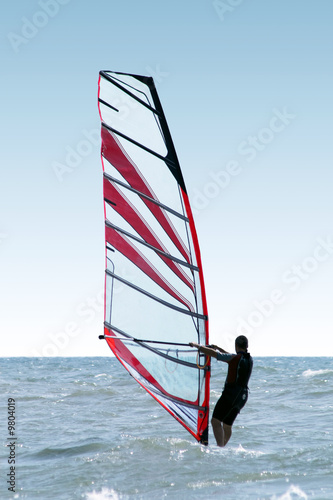 Silhouette of a windsurfer on waves of a sea