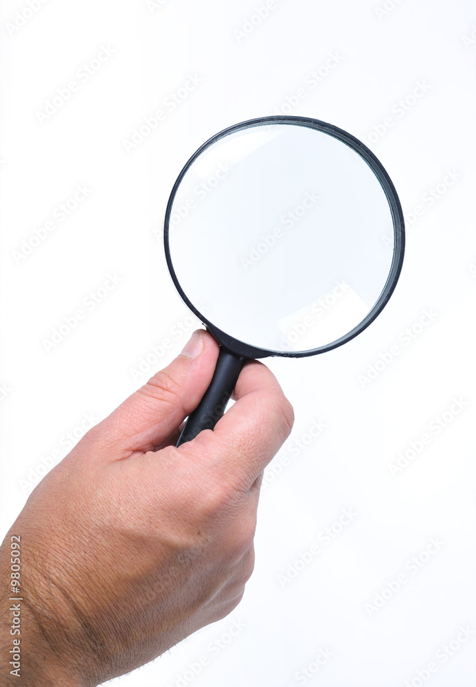 A hand holding a magnifying-glass on white background A hand holding a magnifying-glass on white background