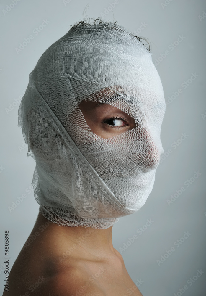 Obraz premium Young man portrait with bandaged face, close up