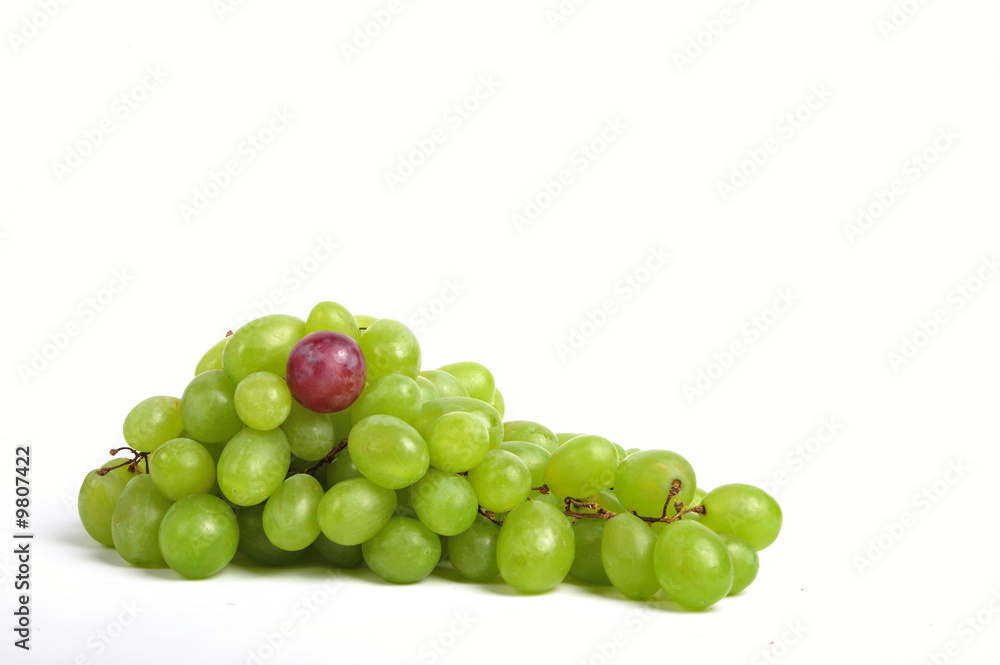 Cluster of white grapes with an outstanding red bean - close up
