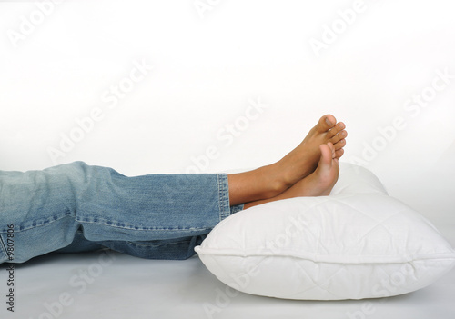 Foot resting on a white pillow, close up