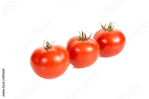 Three tomatos are isolated on a white background.