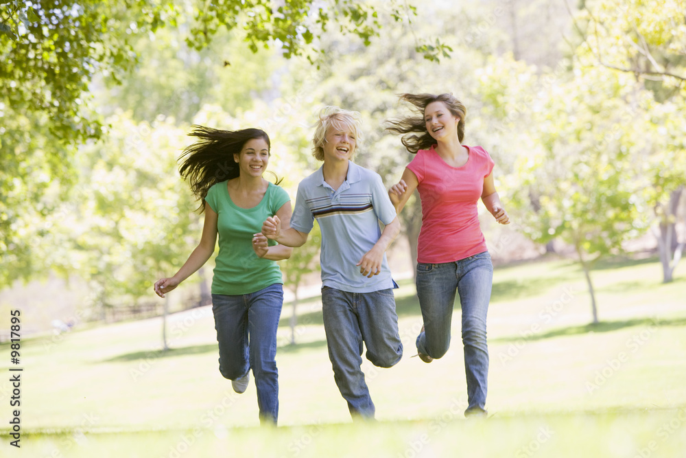 Teenagers Running Through Park