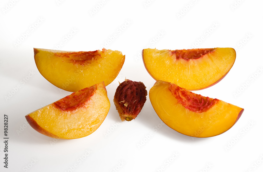 four peach slices and stone on white background four peach slices and stone on white background