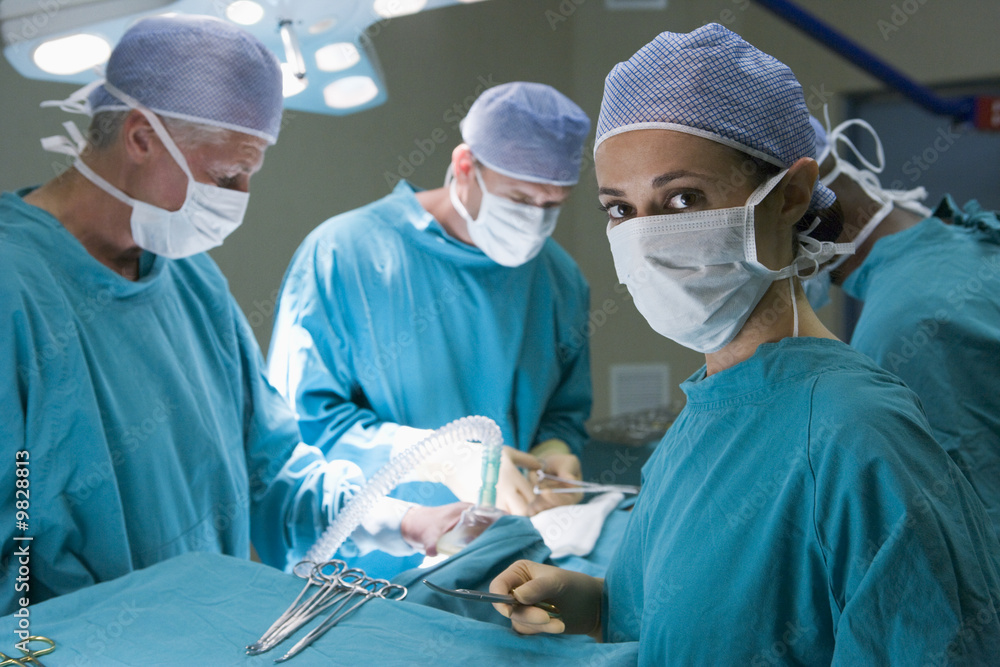 Four Surgeons Getting Ready To Operating On A Patient Four Surgeons Getting Ready To Operating On A Patient