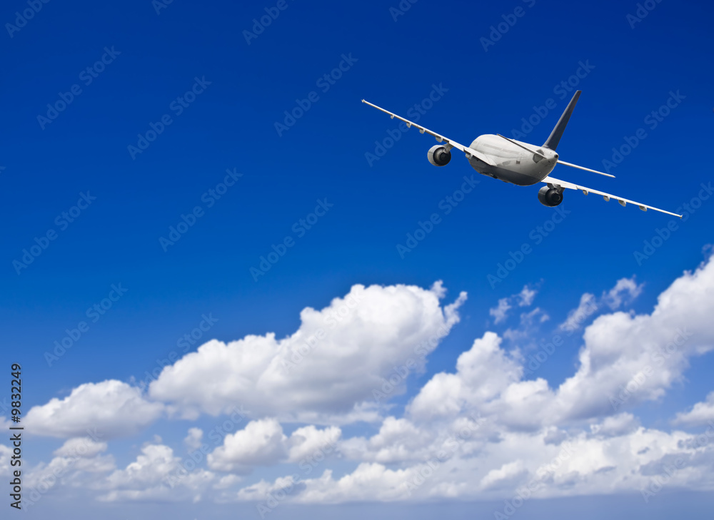 Fototapeta premium Civil aircraft travelling in deep blue skies with some cloud