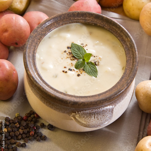 A bowl of freshly made creamy potato soup garnished with mint