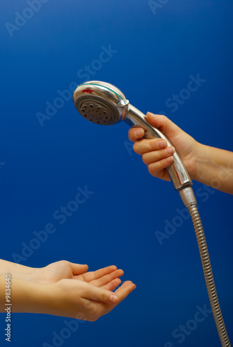 Hand holds a shower on blue background