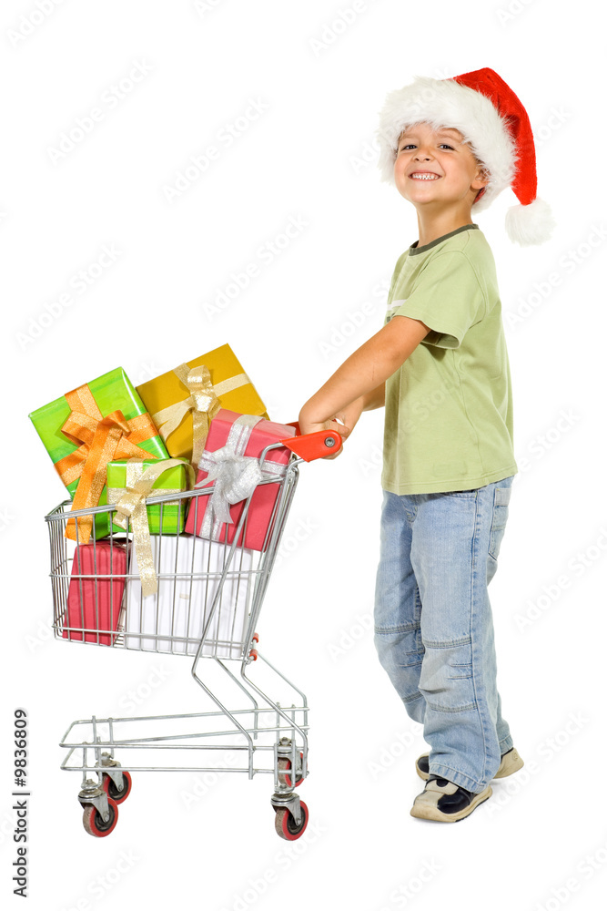 Happy boy shopping for christmas with a cart - isolated Happy boy shopping for christmas with a cart - isolated