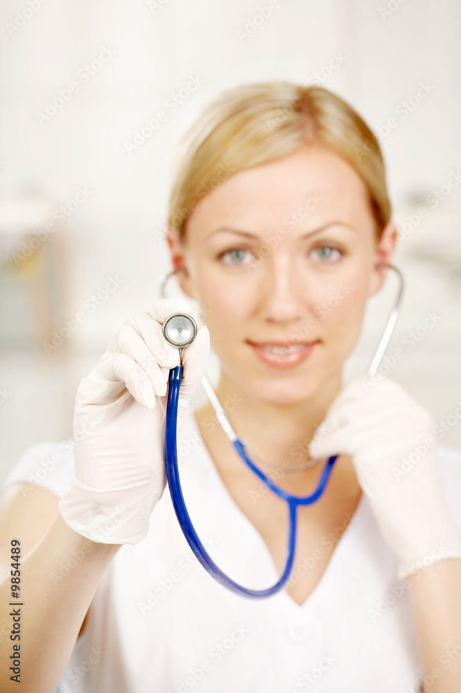 The smiling doctor holds a stethoscope in a hand The smiling doctor holds a stethoscope in a hand