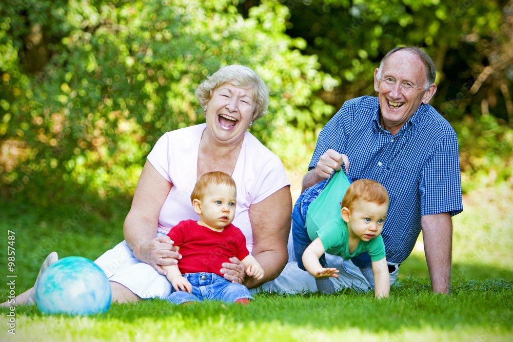 Fototapeta premium Happy handsome grandparents with twin grandsons outdoor portrait