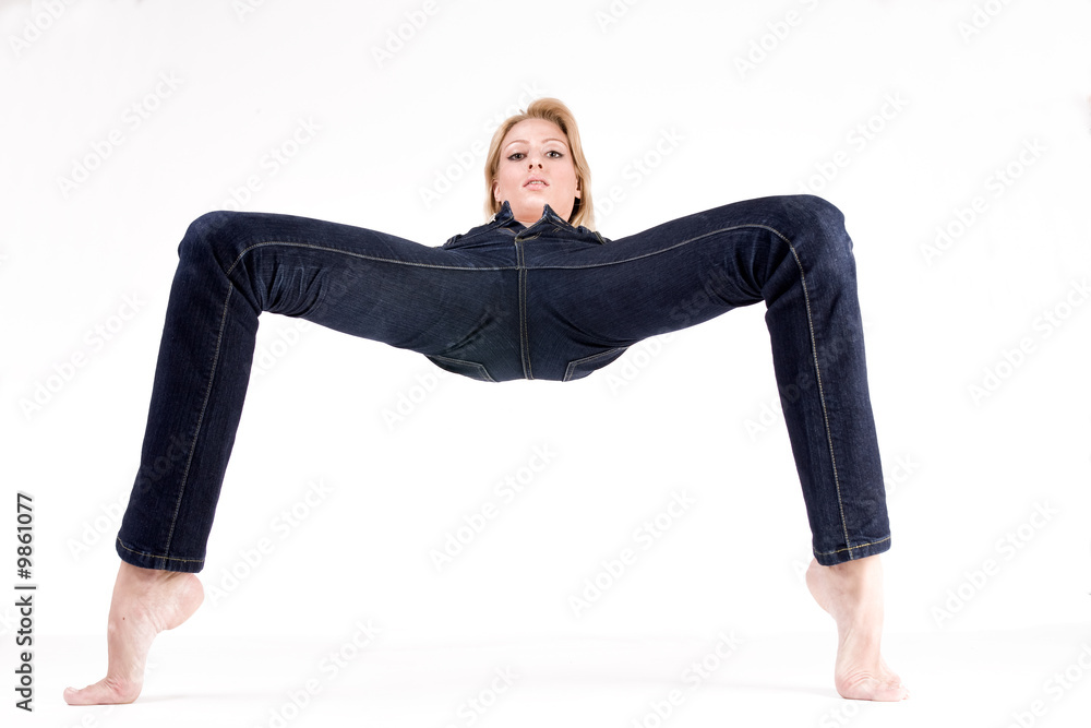 Studio portrait of a blond woman in only jeans in a strange pose