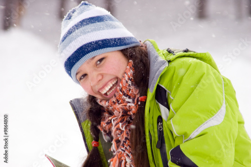 Laughing beautiful girl snowboarder, snowfall