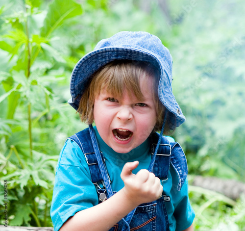 Angry beauty boy in grass, age 4 (series Children)