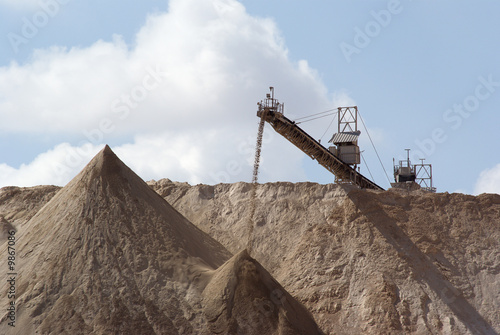Crushed stone pouring off an elevated conveyor onto a large pile