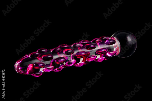 glass dildo with raised pink patterns on black background