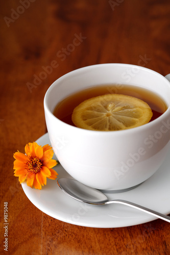 Hot teacup with lemon and flowers.