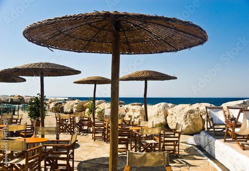 Welcoming beach cafe with straw parasols. Samos Island, Greece
