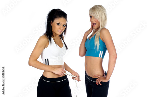 Young woman measuring her waist with a tape measure