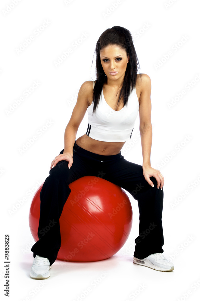 Young brunette woman working out on a red fitness ball Young brunette woman working out on a red fitness ball