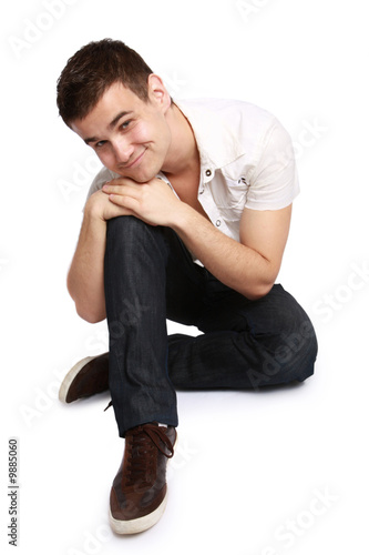 Portrait of a handsome young man sitting on the floor