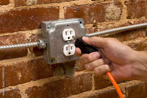 Fotografie a man's hand plugging in an extension cord
