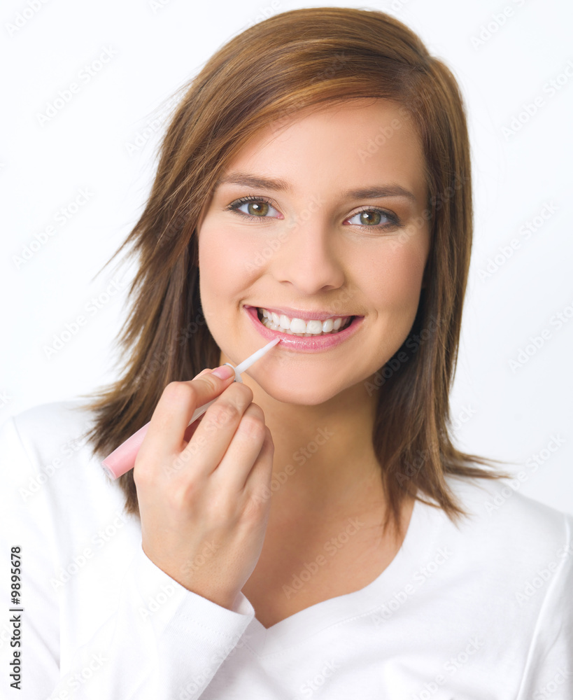 Portrait of beautiful young woman is doing her makeup