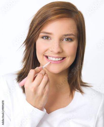 Portrait of beautiful young woman is doing her makeup