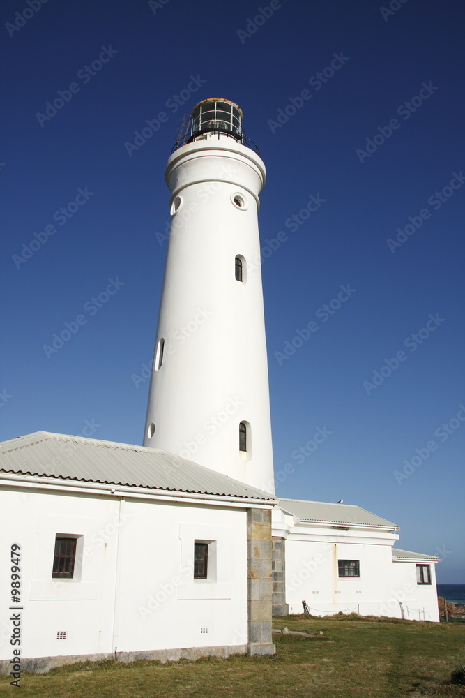 sideview of a brilliant white lighthouse in the late afternoon