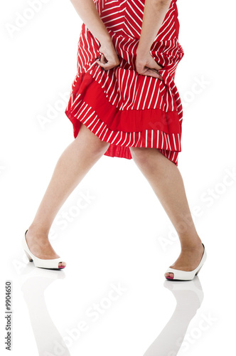 Woman  joining her knees and holding the skirt photo